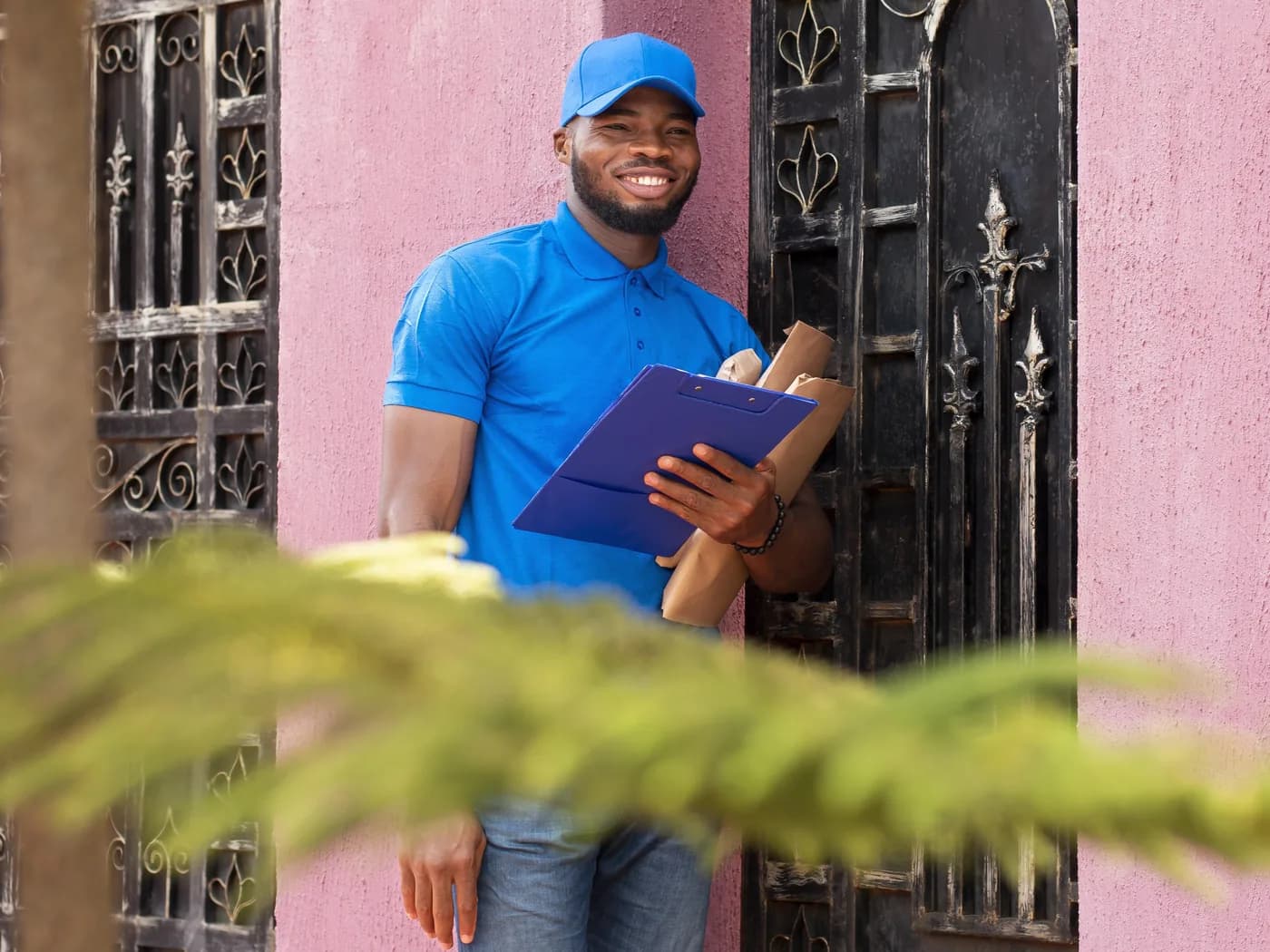 A courier carrying a parcel to a waiting vehicle